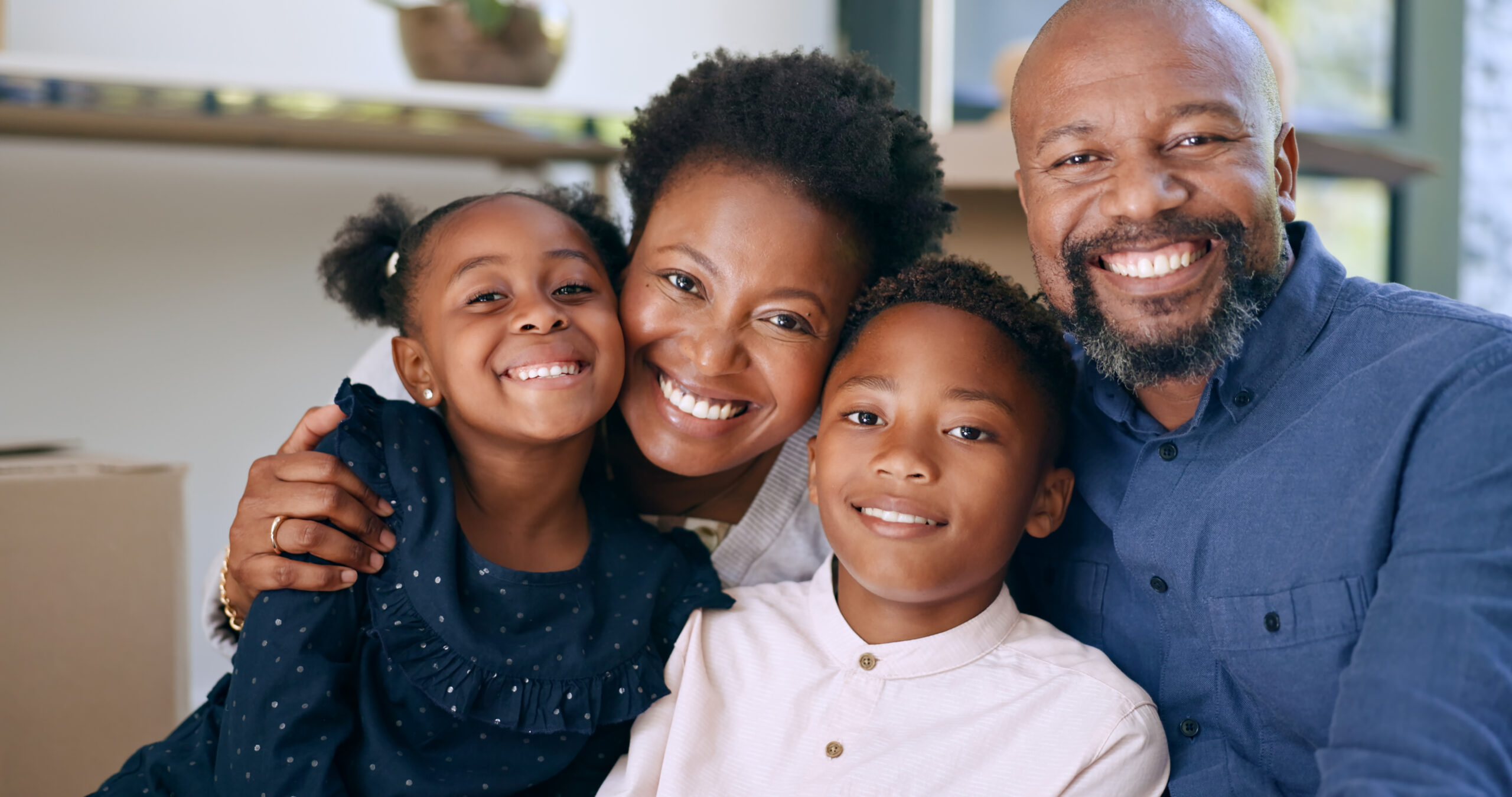 Black family posing for picture smiling and embracing