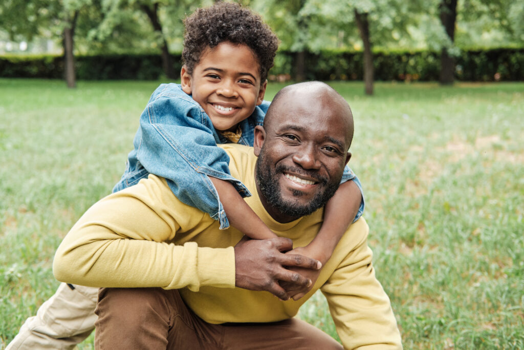 Young boy smiling while embracing smiling father