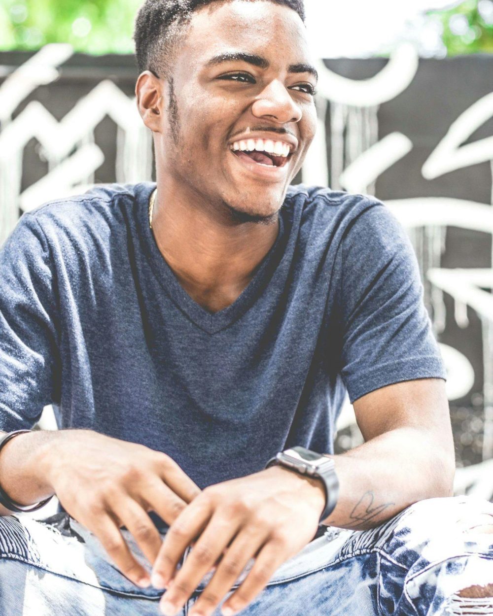 Young black man in blue t-shirt laughing